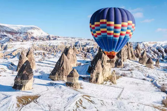 Hot air balloons flying over snowy Cappadocia in winter Turkey